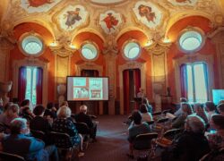 Kuva juhlasalista, jossa käynnissä esitelmä