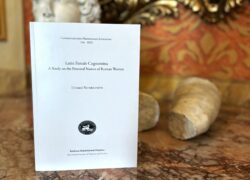 Kuva esiteltävästä kirjasta pöydällä, takana patsaita