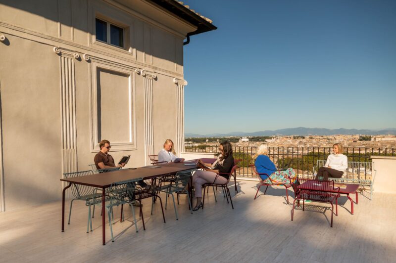 Ihmisiä terassilla auringonlaskussa